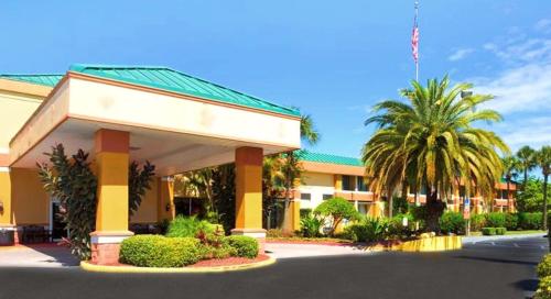 a hotel with a palm tree and a building at Bposhtels Orlando Florida Mall in Orlando