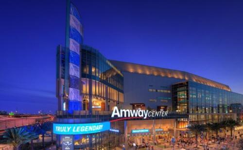 a large building with people in front of it at night at Bposhtels Orlando Florida Mall in Orlando