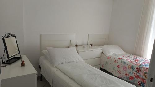 a white bedroom with a bed and a mirror at Scanno in Scanno