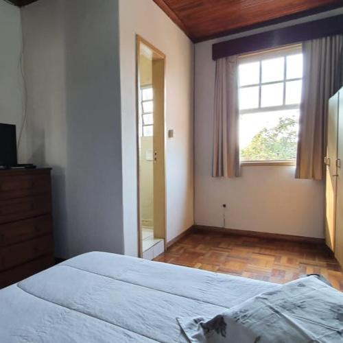 a bedroom with a large bed and a window at Apart Hotel Flomon in Ouro Preto