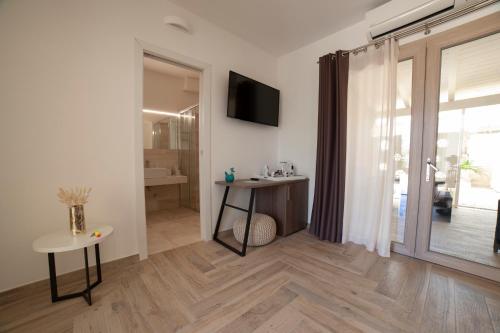 a living room with a table and a tv at Suimi's Hotel in Villasimius