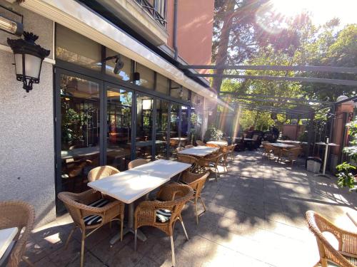 a patio with tables and chairs outside of a restaurant at Hospedium Hotel Los Lanceros in San Lorenzo de El Escorial