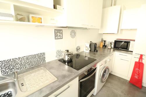 une cuisine avec un évier et une machine à laver dans l'établissement 1 bedroom with direct view to the Old Port 267, à Cannes