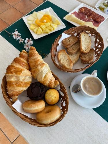 a table with two baskets of bread and other foods at Hospedium Hotel Los Lanceros in San Lorenzo de El Escorial