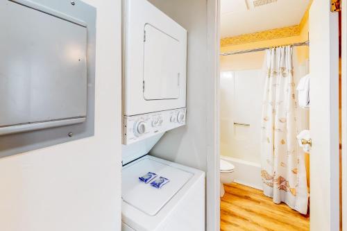 a bathroom with a washer and dryer and a toilet at Beach Front #203 in Gulf Shores
