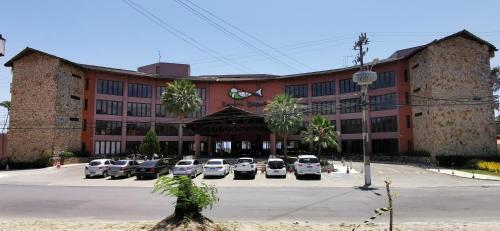a large building with cars parked in a parking lot at Blanco Beach Suite Privada, Cumbuco in Cumbuco