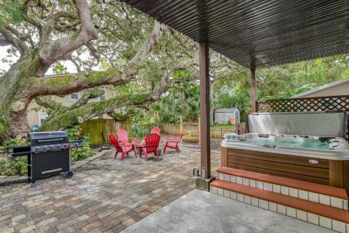 a patio with a hot tub and chairs and a grill at Golden Mile Beach Retreat in St. Augustine