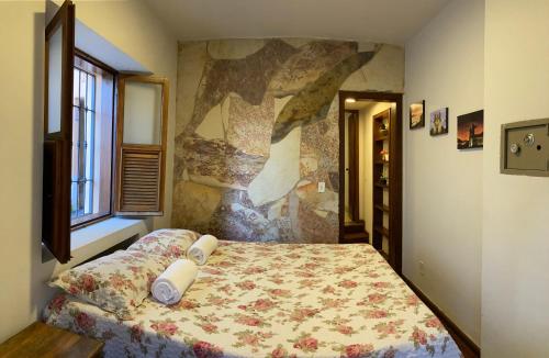 a bedroom with a bed with a floral bedspread at º Real Central Suite º in Ouro Preto