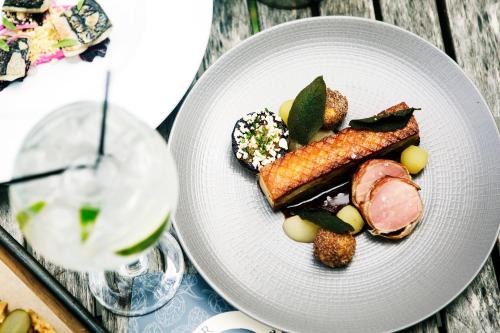 a white plate with food and a glass of wine at The Boot Inn in Burton upon Trent