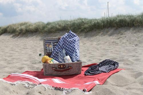 una maleta en la arena en una playa en Ferienhaus Sonne Mond und Sterne b, en Steffenshagen