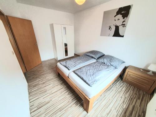 - une chambre avec un lit et une photo sur le mur dans l'établissement Lieblingsmensch Oberhausen mit Terrasse, à Oberhausen