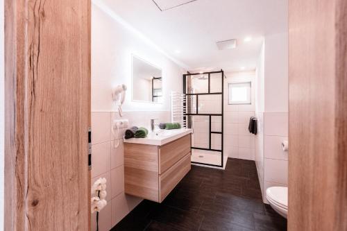La salle de bains blanche est pourvue d'un lavabo et de toilettes. dans l'établissement Southern Stables Ranch, à Bannberg