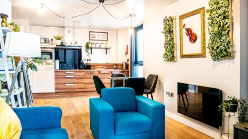 a living room with blue chairs and a fireplace at Beyond Blonk Apartments in Sheffield