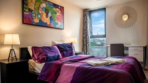 sypialnia z łóżkiem z fioletową pościelą i oknem w obiekcie Beyond Blonk Apartments w Sheffield