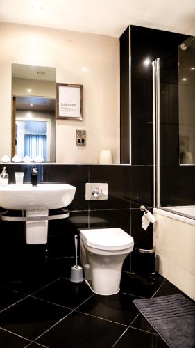 a bathroom with a white toilet and a sink at Beyond Blonk Apartments in Sheffield