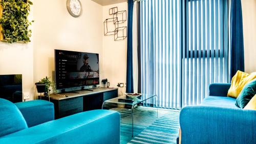 a living room with blue couches and a tv at Beyond Blonk Apartments in Sheffield