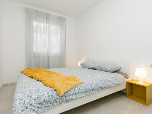 een slaapkamer met een bed met een gele deken erop bij Apartment Aria in Poreč