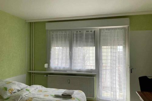ein Schlafzimmer mit einem Bett und zwei Fenstern in der Unterkunft Studio Lora RM 1184L in Saint-Louis
