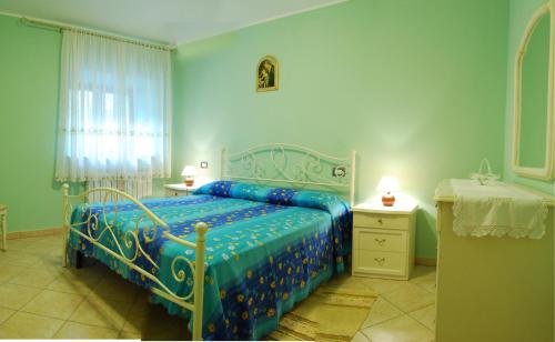 1 dormitorio con 1 cama azul, 2 mesas y una ventana en B&B Da Franca, en Camporgiano