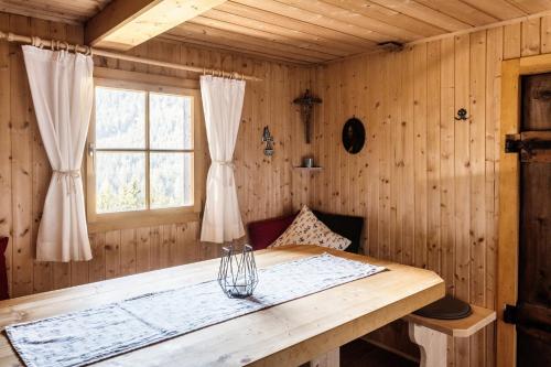 a wooden room with a table and a window at Fohlenwies - romantische Berghütte in Alleinlage Osttirol in Lienz