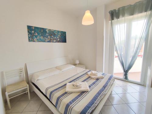 a bedroom with a bed and a chair and a window at La Casa del Sole in Santa Marinella