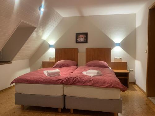 a bedroom with a large bed with pink sheets at Hotel Gold´ne Krone in Oppenheim