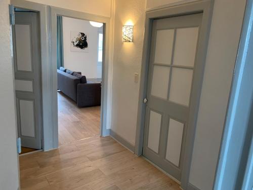 un couloir avec deux portes et un salon dans l'établissement Elégant Appartement T3 hypercentre de Mazamet, à Mazamet