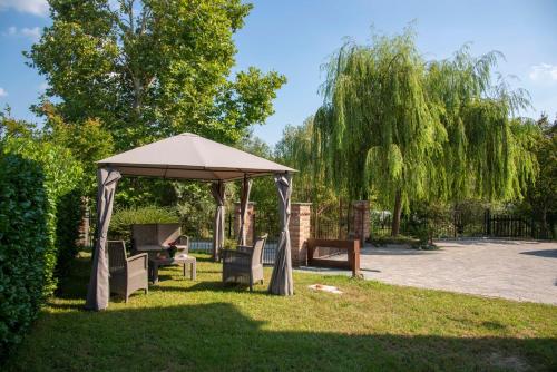 a gazebo with chairs and a table in the grass at Agriturismo Cascina Costa in Cassago Brianza