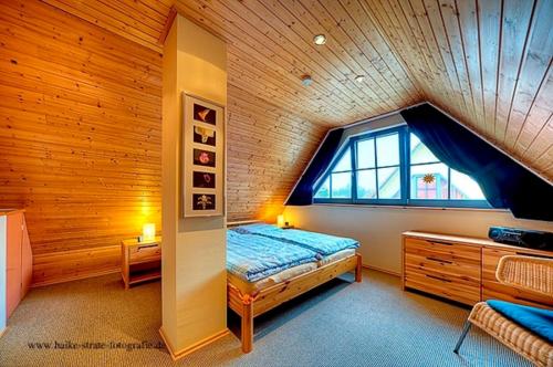 ツィングストにあるSonnenscheinのベッドと窓が備わる屋根裏部屋