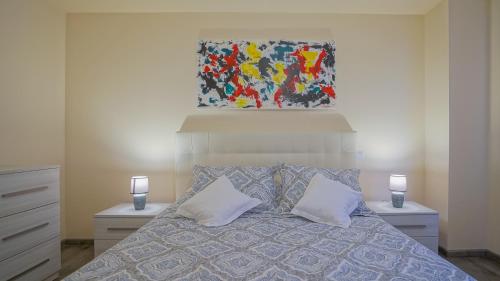 a bedroom with a bed with two pillows and a painting at Coroni Apart 1 Cu Vedere Panoramica Brasov in Braşov