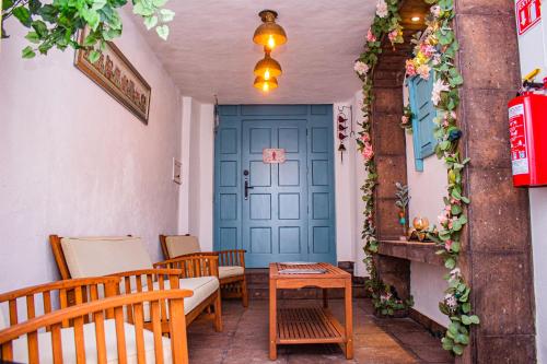 a living room with a blue door and chairs at Casa Cardennal in San Miguel de Allende