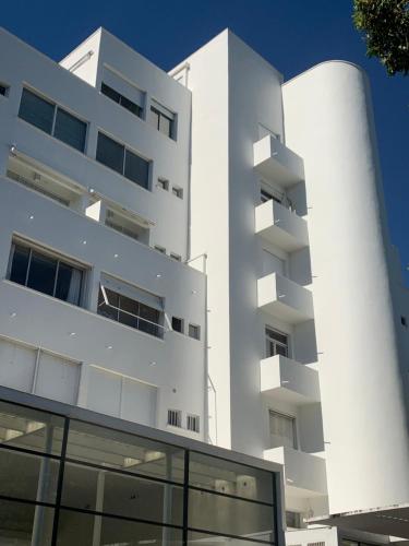 a white apartment building with a window at ÉLÉGANT STUDIO DANS BATIMENT HISTORIQUE in Saint-Tropez