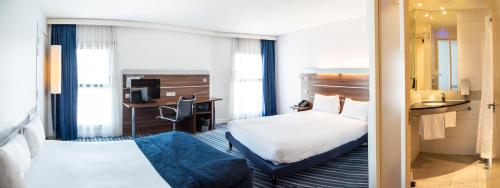 a hotel room with two beds and a desk at Hôtel Marseille Centre Gare Saint-Charles in Marseille
