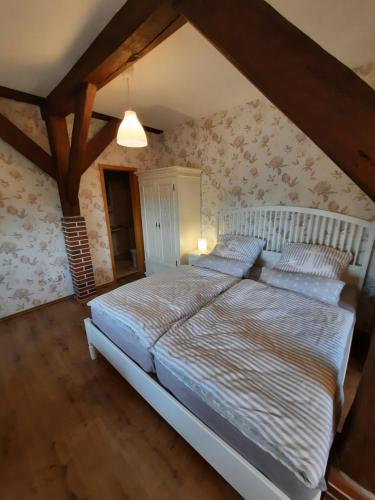 - une chambre mansardée avec un grand lit dans l'établissement Apartment Weitblick, à Butjadingen