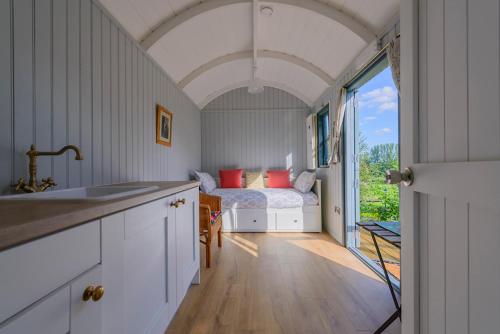 a kitchen with a bedroom with a bed and a window at Hawthorn Hut Kilkenny Glamping at Jenkinstown House in Tower Bridge
