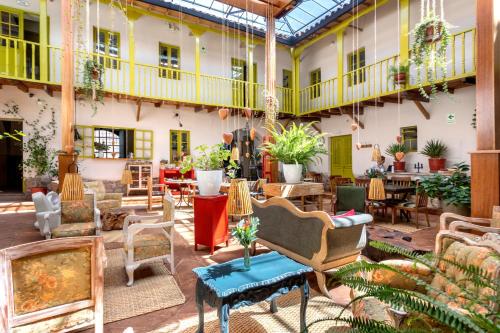 einen Innenhof mit Stühlen und Tischen in einem Gebäude in der Unterkunft Niños Hotel Fierro in Cusco