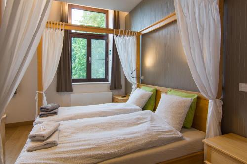 2 bedden in een slaapkamer met een raam bij Het Dorpshuys - vakantiewoning tot 12 personen in Maaseik