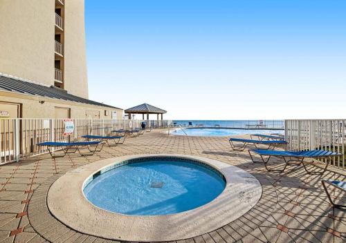 una piscina con mesas y sillas junto a un edificio en Beach House by TS, en Destin