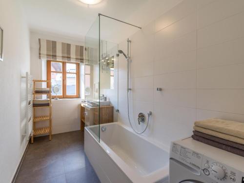 a bathroom with a tub and a washing machine at Villa Grete, St. Johann in Tirol in Sankt Johann in Tirol
