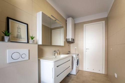 a bathroom with a sink and a washing machine at Apartment Emarin in Banjole