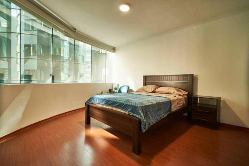 1 dormitorio con cama y ventana grande en QuitoSuite Amoblada ubicación privilegiada, en Quito