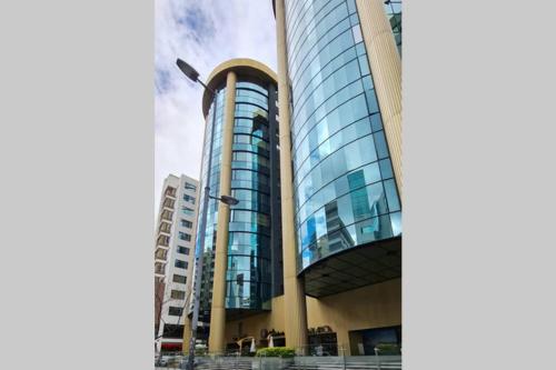 a tall building with glass windows in a city at QuitoSuite Amoblada ubicación privilegiada in Quito