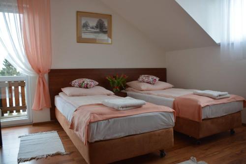 two twin beds in a room with a window at Siedlisko Roztocze Potoczek in AdamÃ³w