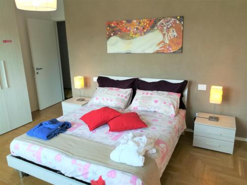 a bedroom with a bed with red and blue pillows at ARCHITECT'S APARTMENT PADOVA in Padova
