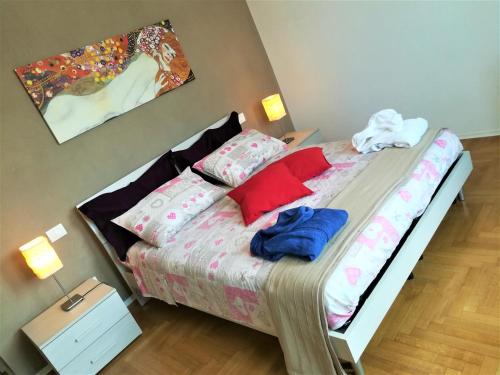 a bedroom with a bed with red and blue pillows at ARCHITECT'S APARTMENT PADOVA in Padova