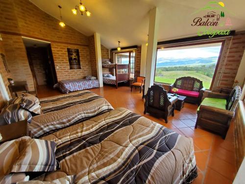a bedroom with two beds and a large window at Balcon al Cotopaxi Hosteria in Sangolquí