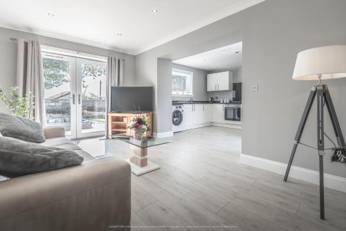 a living room with a couch and a television at 1 Bed Cottage-Sleeps 2-Parking-Pets-Hot Tub in Kelty