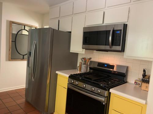 a kitchen with a stainless steel refrigerator and a microwave at Mid Century Designer House - Large & Unique in Chapel Hill