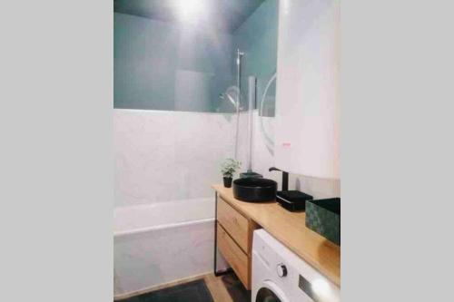 a bathroom with a tub and a sink and a toilet at Appartement 2/3 pers, centre ville avec parking. in Saint-Brevin-les-Pins
