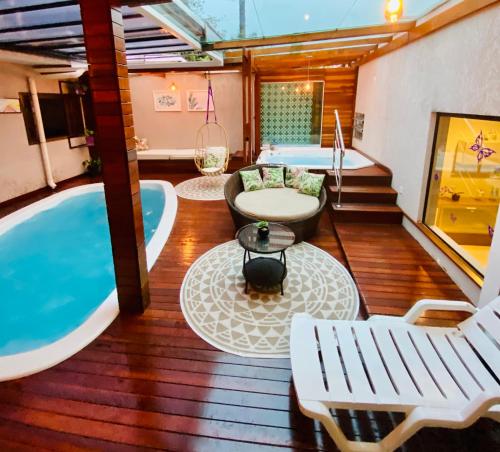 um quarto com uma banheira, uma mesa e cadeiras em CWB 997 com piscina aquecida jacuzzi e Playground em Curitiba